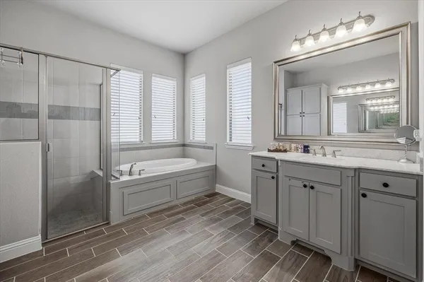 a bathroom with a tub sink shower and mirror