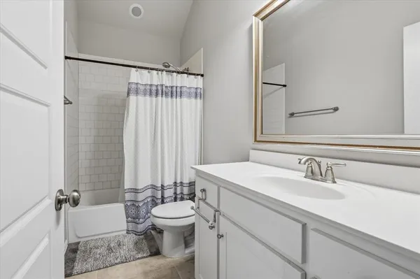 a bathroom with a sink a toilet a mirror and shower