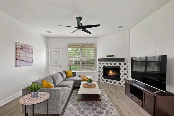 a living room with furniture a fireplace and a flat screen tv