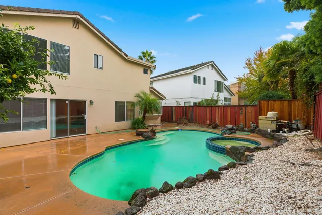 a view of a swimming pool in the backyard of house