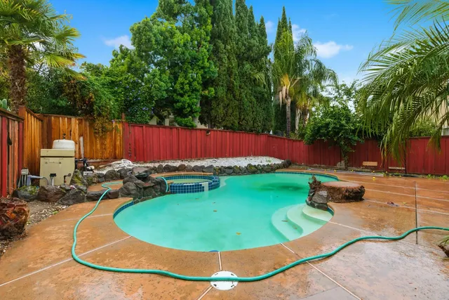 a view of a house with a swimming pool and a yard