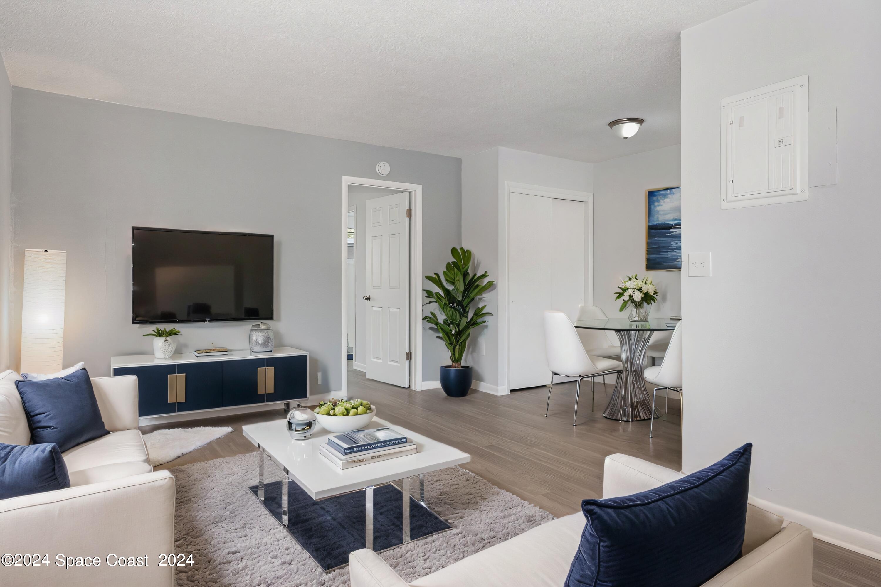 115 Seminole Avenue West, Unit 209 Melbourne, FL 32901 - Photo 2 of 23 a living room with furniture and a flat screen tv