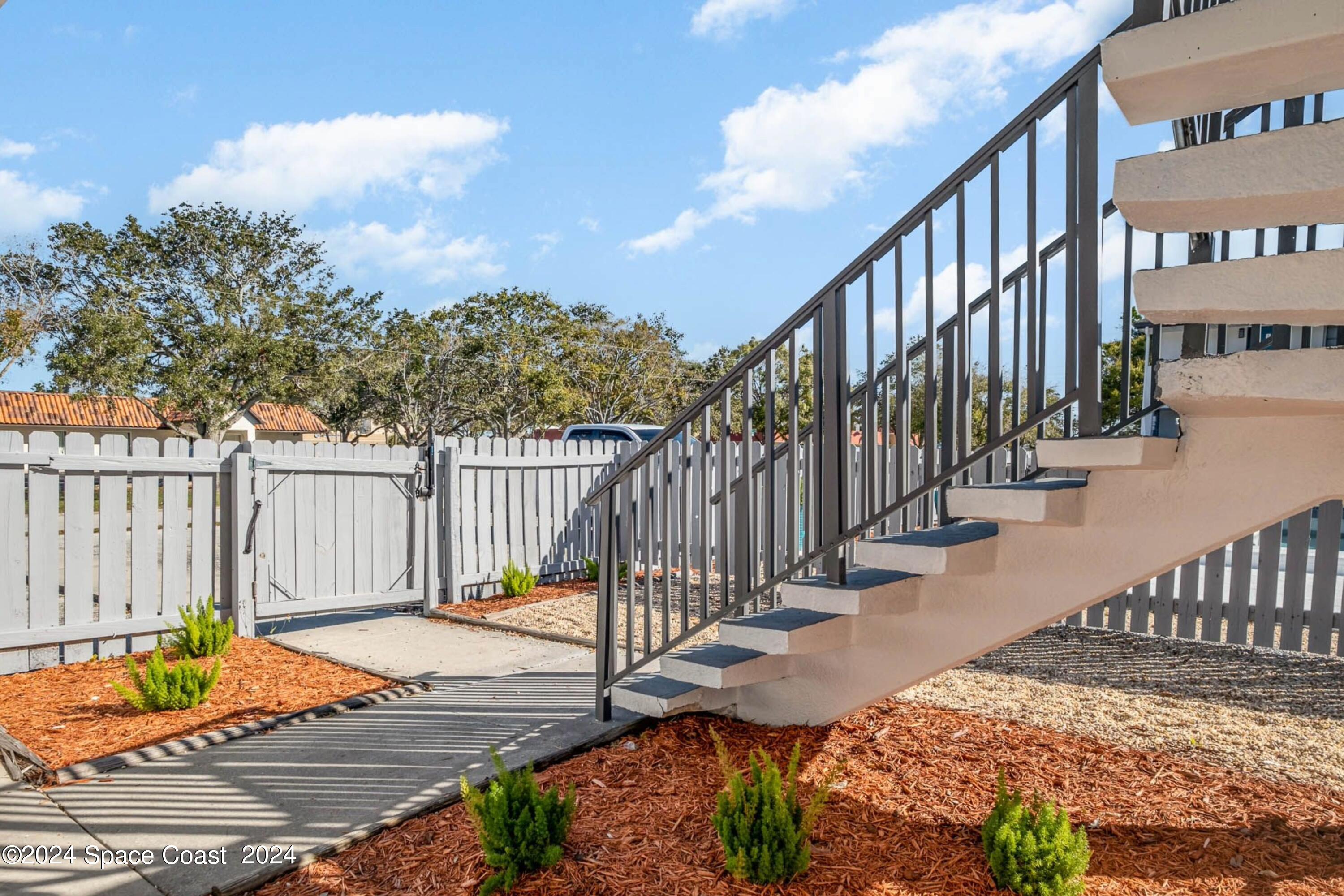 115 Seminole Avenue West, Unit 209 Melbourne, FL 32901 - Photo 21 of 23 a balcony with wooden floor and fence