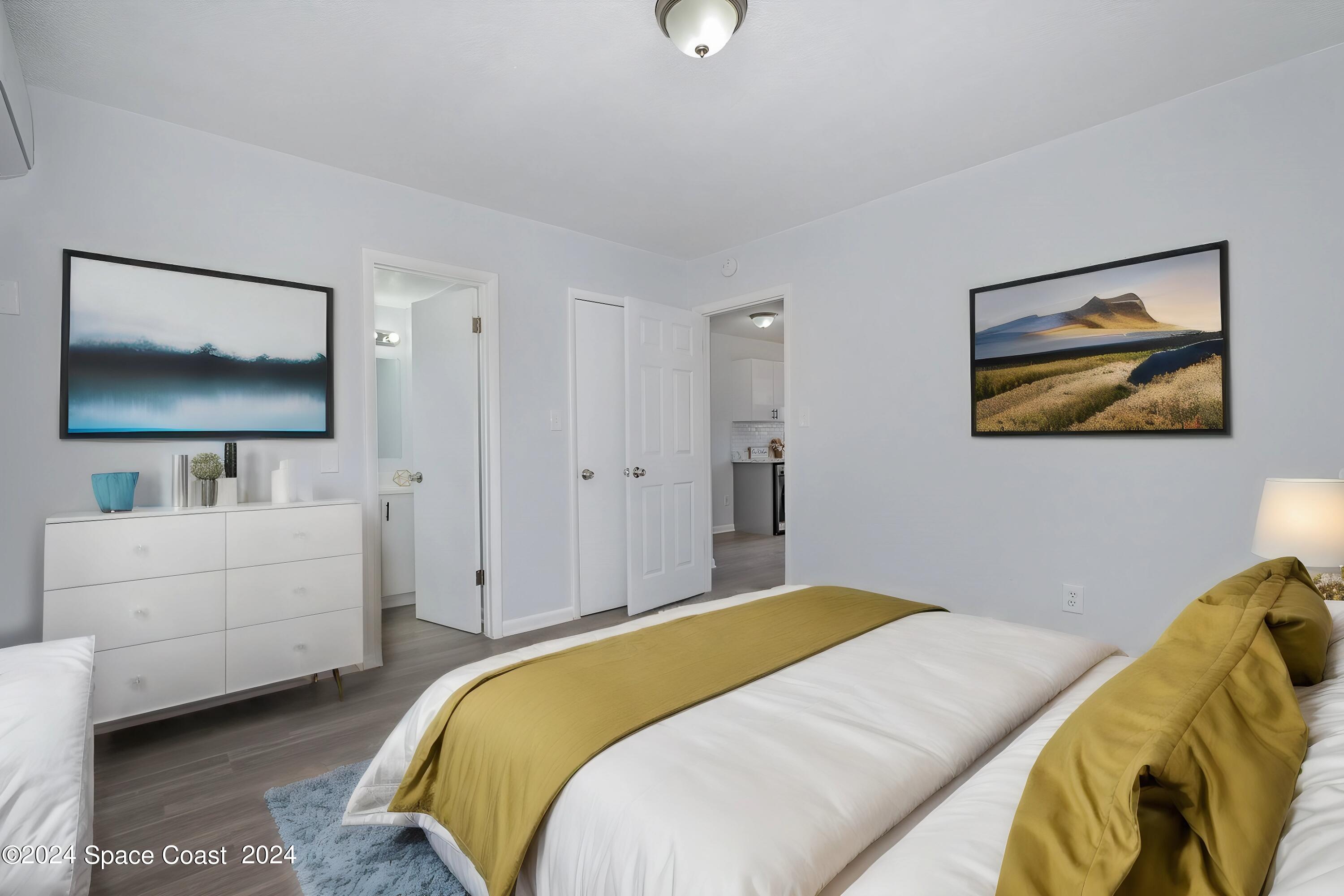 115 Seminole Avenue West, Unit 209 Melbourne, FL 32901 - Photo 6 of 23 a bedroom with a bed and a flat screen tv