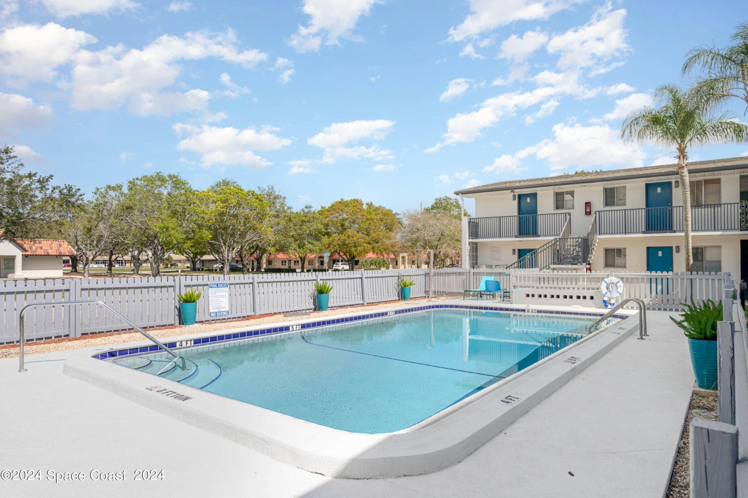 115 Seminole Avenue West, Unit 209 Melbourne, FL 32901 - Photo 9 of 23 a view of a swimming pool with a lounge chair