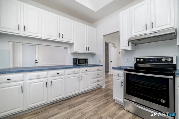 a kitchen with granite countertop white cabinets and stainless steel appliances