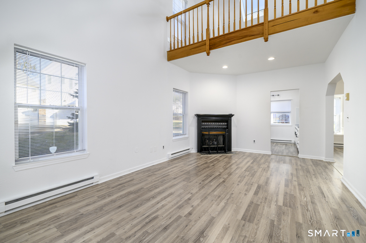 905 Oronoke Road, Unit 13 Waterbury, CT 06708 - Photo 9 of 28 a view of empty room with wooden floor and fireplace