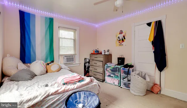 a bedroom with a bed and a flat tv screen on dresser