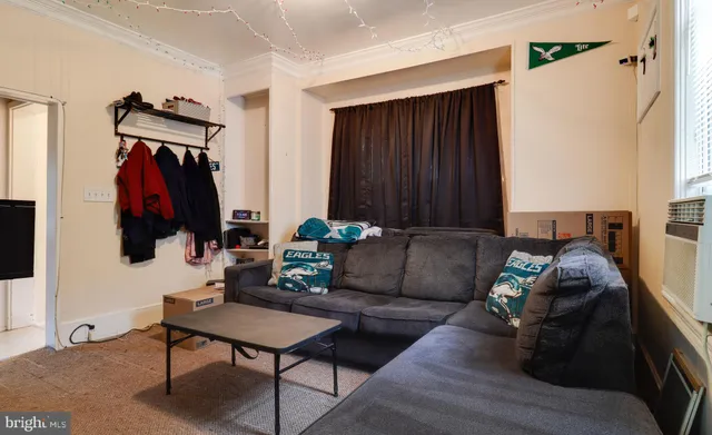 a living room with furniture and a painting on the wall