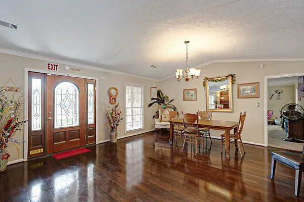 a view of a dining room with furniture chandelier and wooden floor