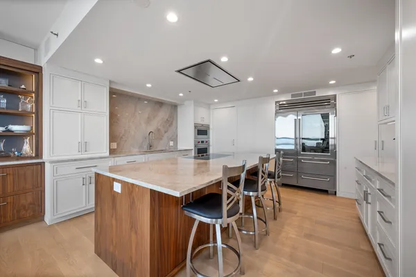 a kitchen with stainless steel appliances kitchen island granite countertop a table and chairs in it