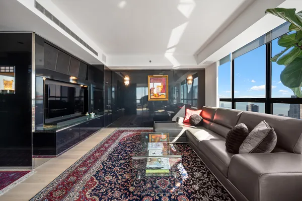 a living room with furniture a flat screen tv and kitchen view