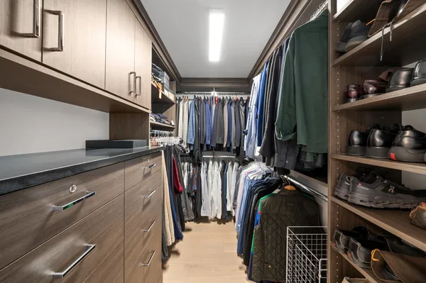 a view of walk in closet with clothes and shoes