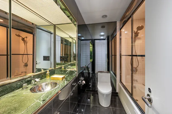 a bathroom with a granite countertop tub sink toilet and mirror