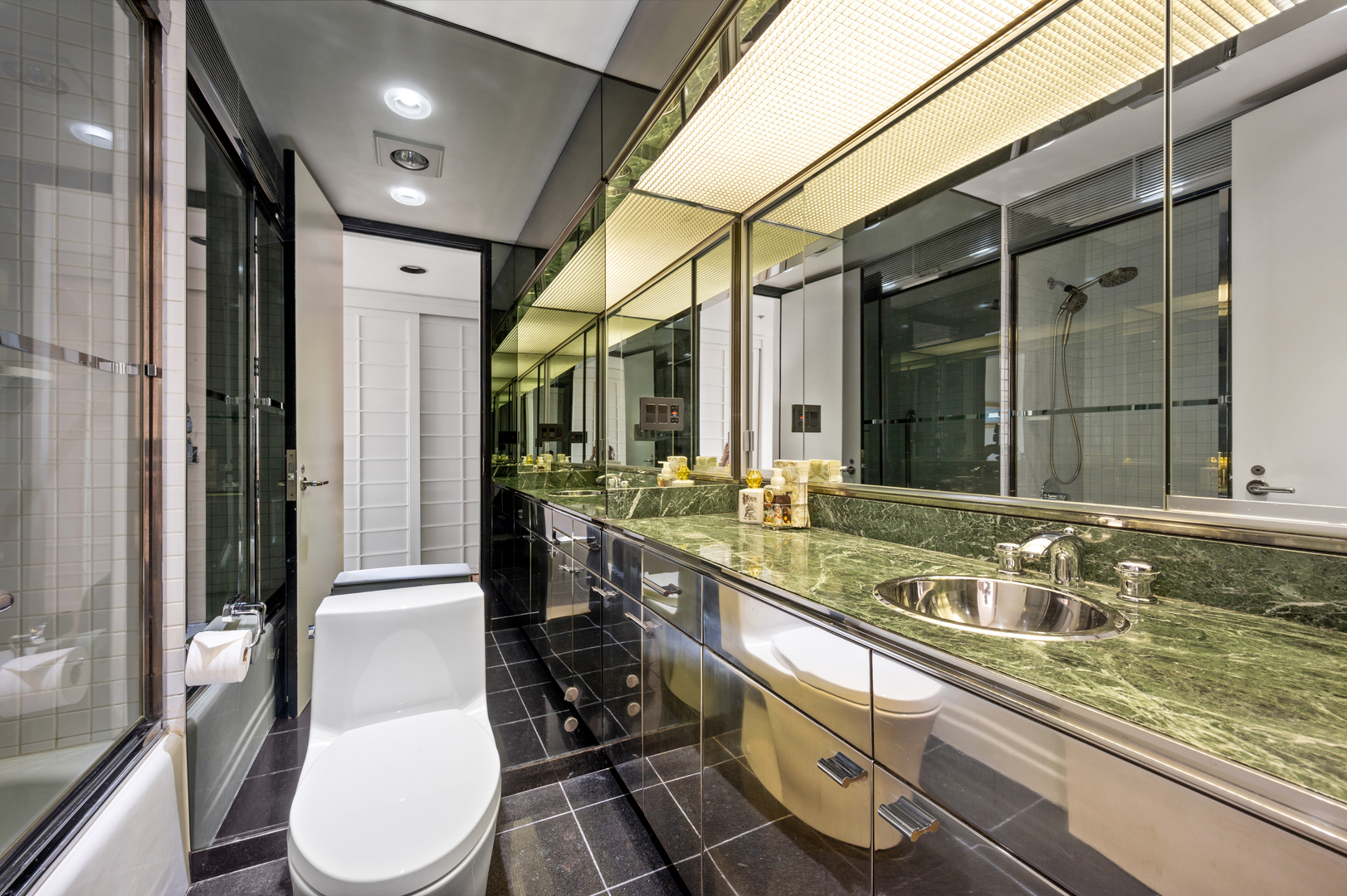 180 East Pearson Street, Unit 6907 Chicago, IL 60611 - Photo 29 of 44 a bathroom with a granite countertop sink a toilet a mirror and shower