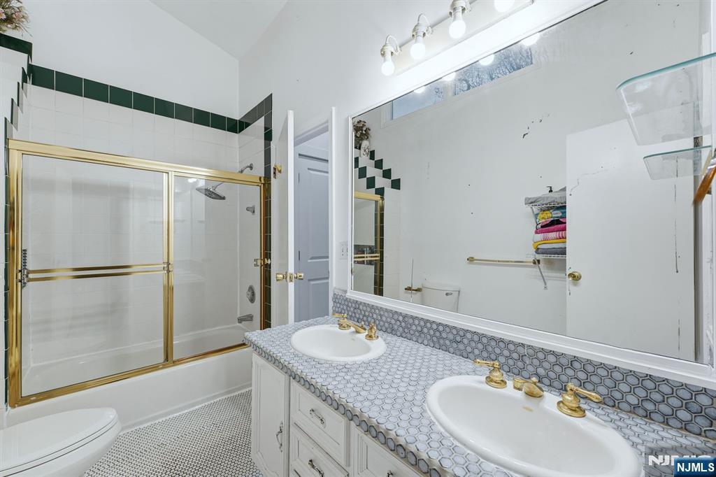 31 West Street Closter, NJ 07624 - Photo 12 of 18 a bathroom with a granite countertop shower sink and mirror