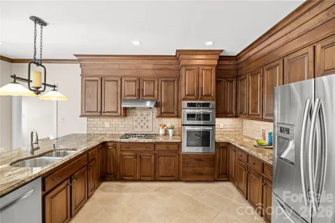 a kitchen with stainless steel appliances granite countertop a sink stove and cabinets