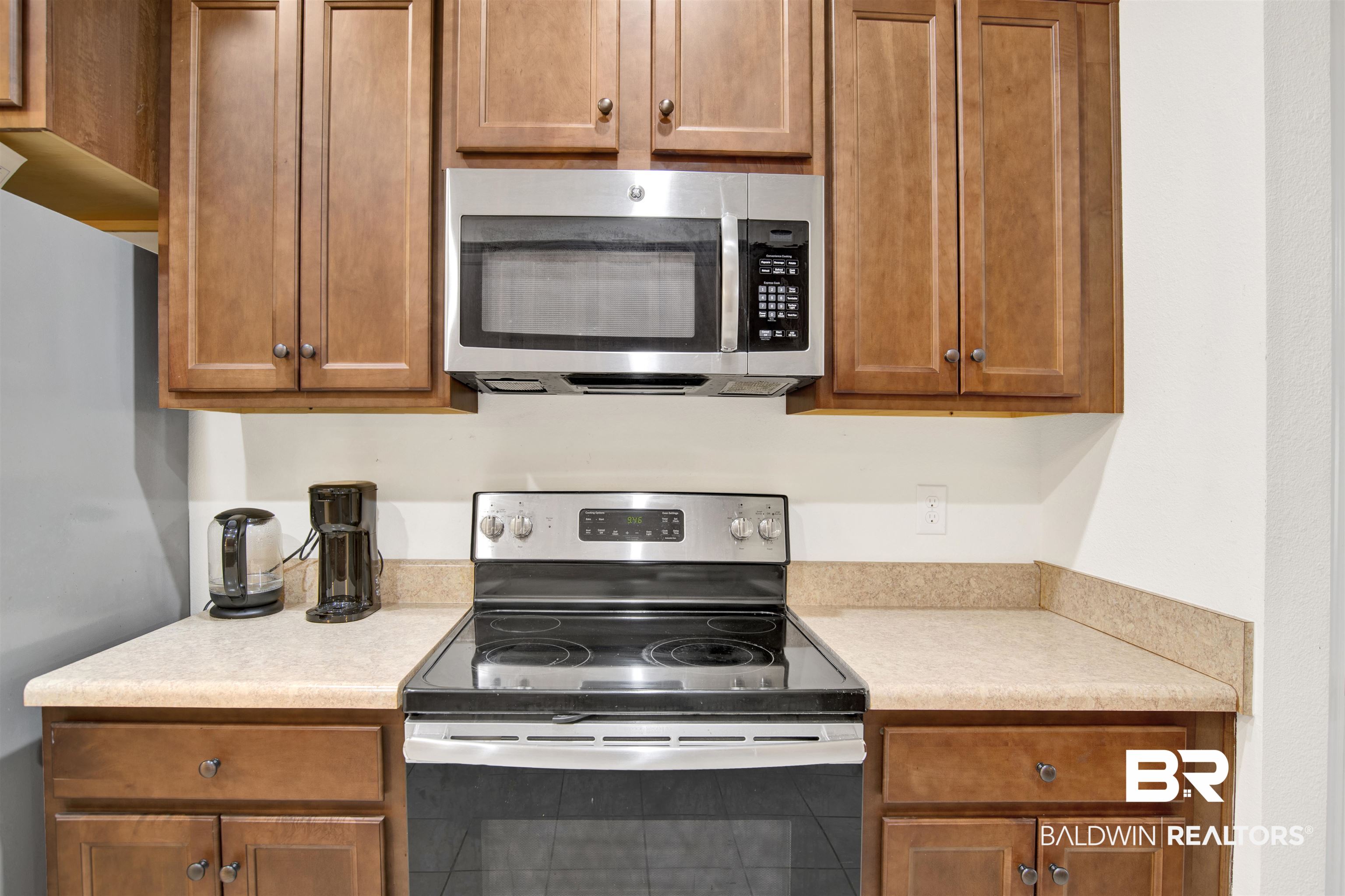 1468 Surrey Loop Foley, AL 36535 - Photo 10 of 28 Kitchen with stainless steel appliances, light countertops, and brown cabinetry
