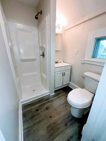 a bathroom with a granite countertop toilet a sink and a shower