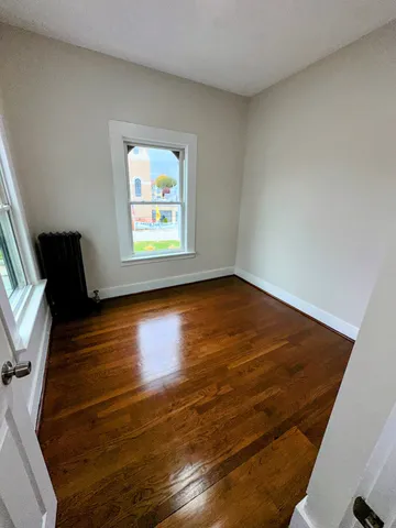 a view of room with window and wooden floor