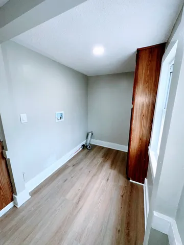 an empty room with wooden floor and door