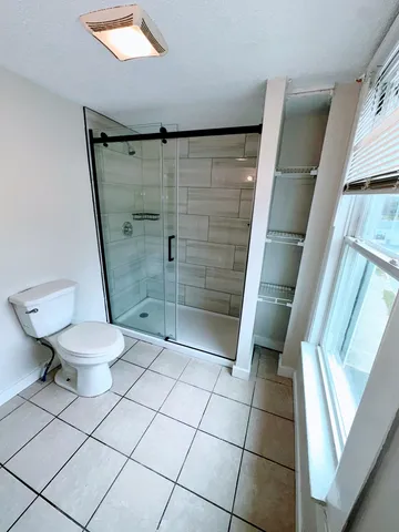 a bathroom with a toilet and a shower