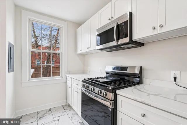 a kitchen with stainless steel appliances granite countertop a stove microwave and cabinets