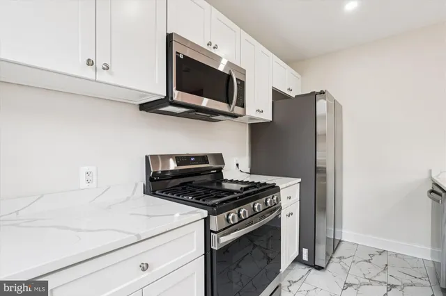 a kitchen with stainless steel appliances a stove microwave and refrigerator