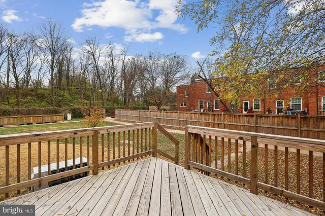a view of a balcony with wooden floor and fence