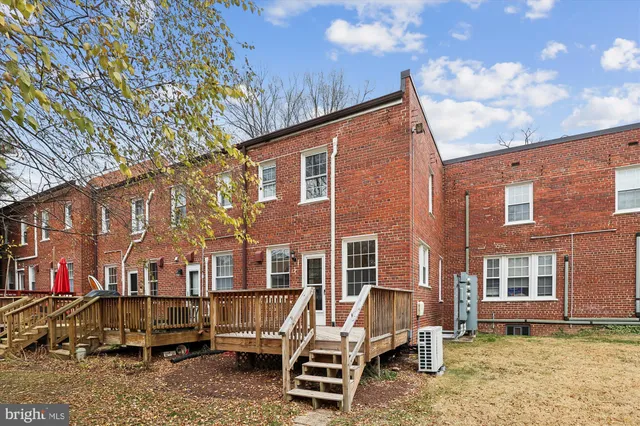 a view of a brick house with a yard and lawn chairs