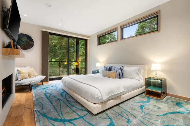 a bedroom with a large bed and a flat tv screen on dresser