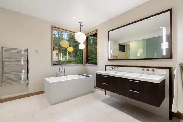 a bathroom with a tub sink and mirror
