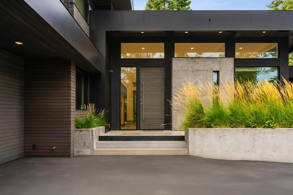 a view of a house with a large window and potted plants