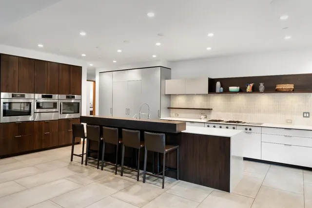 a kitchen with stainless steel appliances granite countertop a stove a sink a microwave a center island and a refrigerator