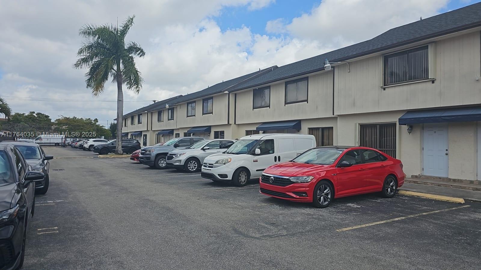 8430 Northwest 8th Street, Unit A11 Miami, FL 33126 - Photo 1 of 23 a group of cars parked in front of a house