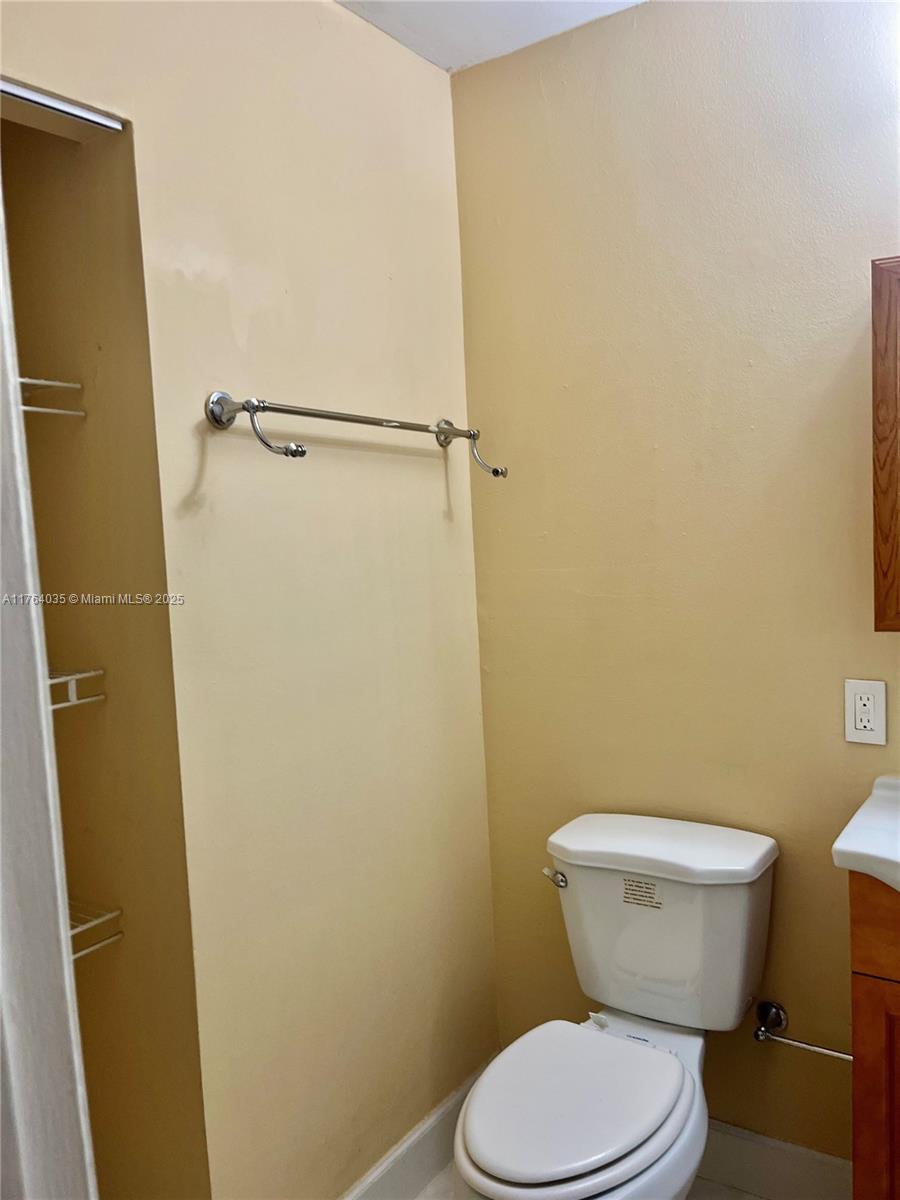 8430 Northwest 8th Street, Unit A11 Miami, FL 33126 - Photo 20 of 23 a white toilet sitting next to a wooden wall