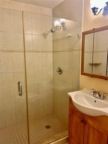 a bathroom with a sink a shower and a mirror