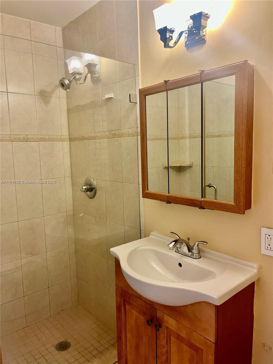 8430 Northwest 8th Street, Unit A11 Miami, FL 33126 - Photo 22 of 23 a bathroom with a sink a shower and a mirror