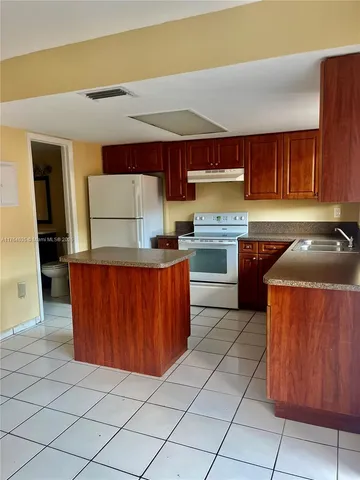 a kitchen with granite countertop a stove top oven sink and cabinets