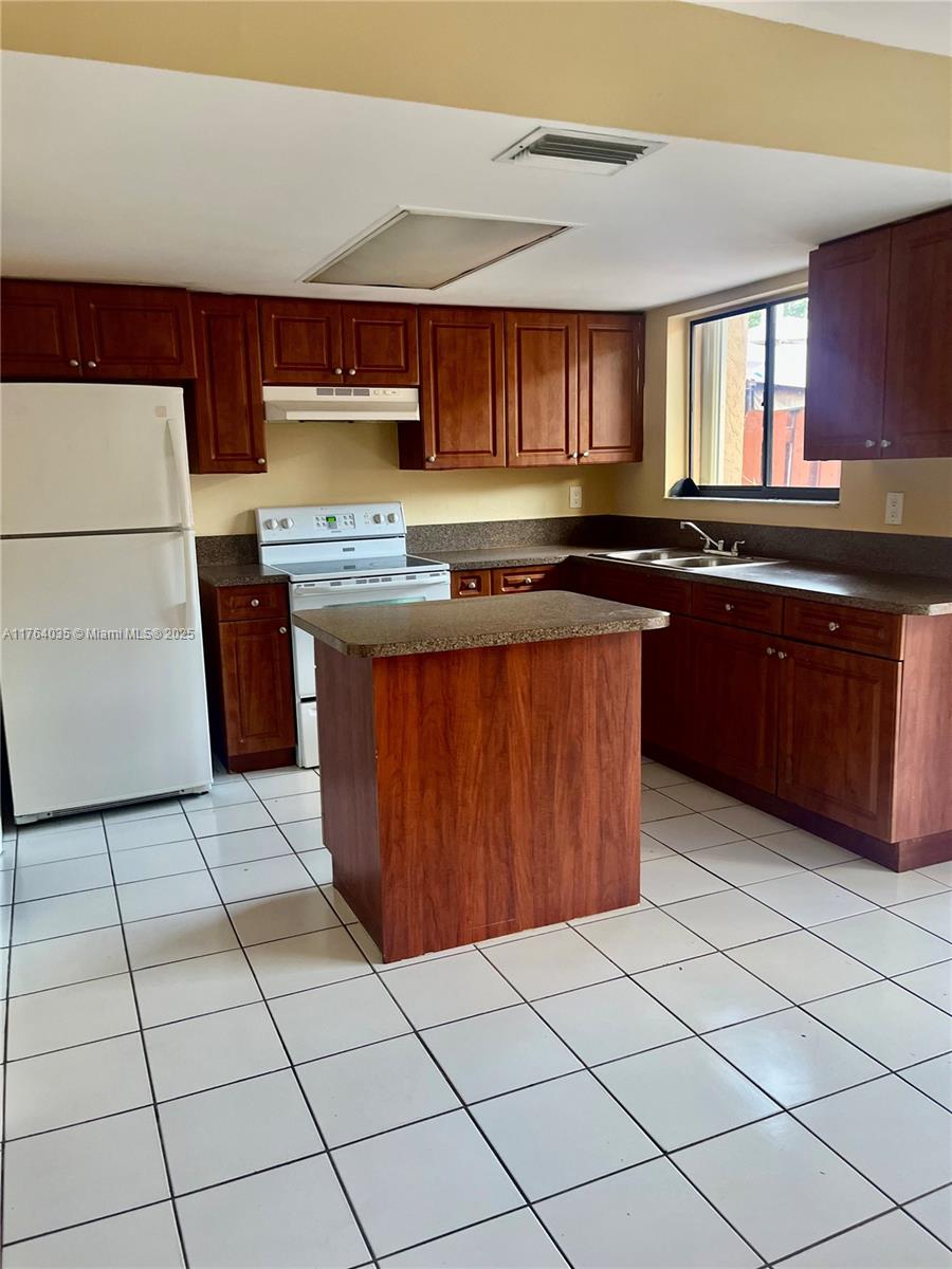 8430 Northwest 8th Street, Unit A11 Miami, FL 33126 - Photo 6 of 23 a kitchen with stainless steel appliances granite countertop a stove a sink and a microwave