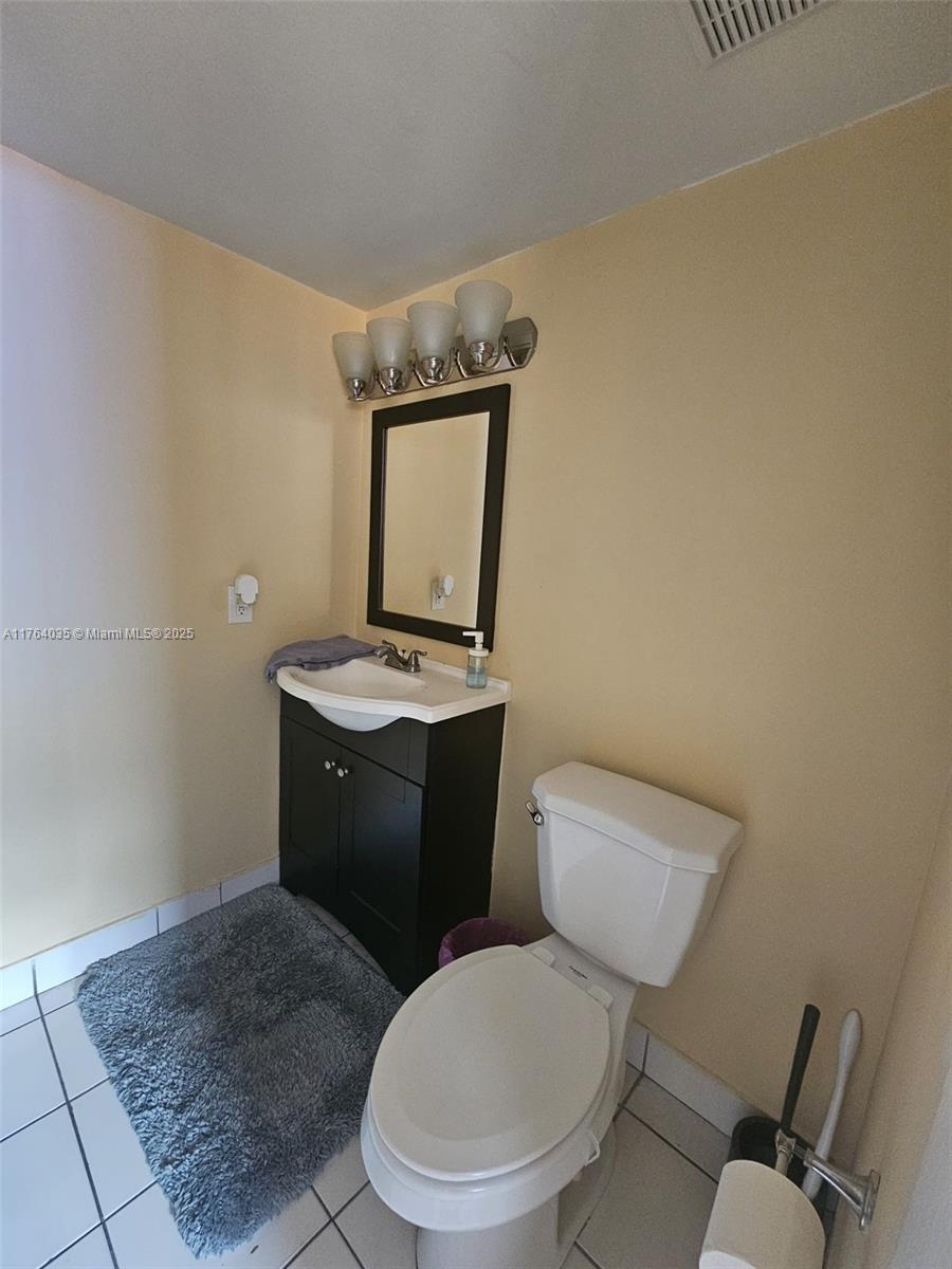 8430 Northwest 8th Street, Unit A11 Miami, FL 33126 - Photo 9 of 23 a bathroom with a toilet a sink and mirror