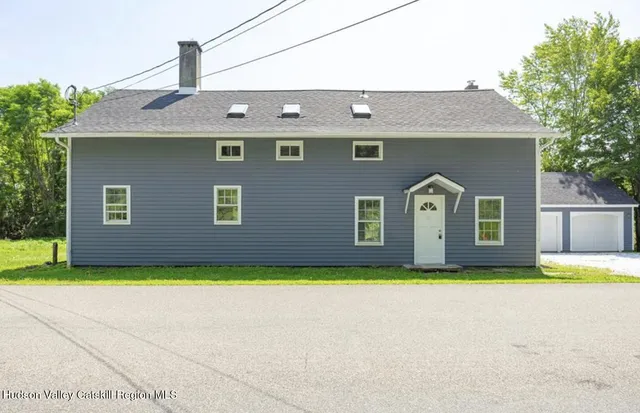 a front view of house with yard and trees
