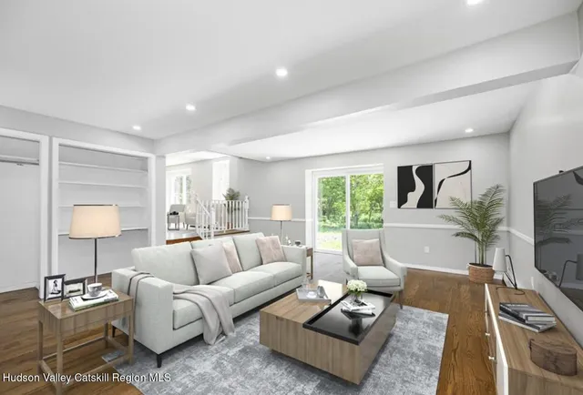 a living room with furniture flat screen tv and a large window