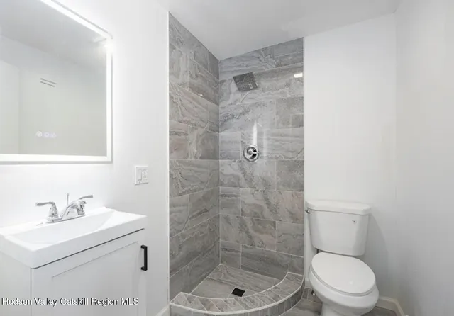 a bathroom with a shower a toilet and a sink