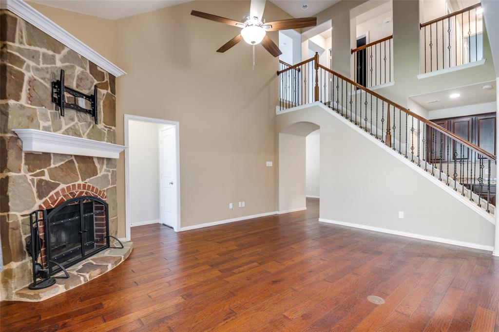 a view of a livingroom with wooden floor fireplace and a window