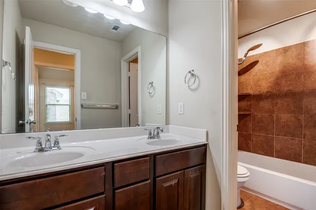 a bathroom with a granite countertop sink a toilet and shower