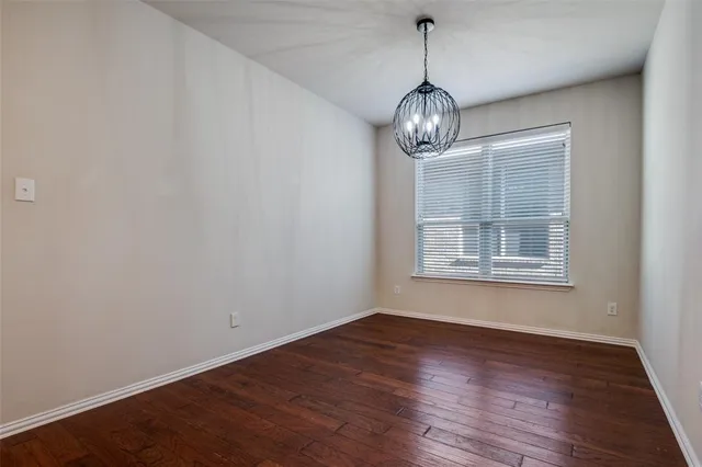 a view of a room with wooden floor chandelier and windows