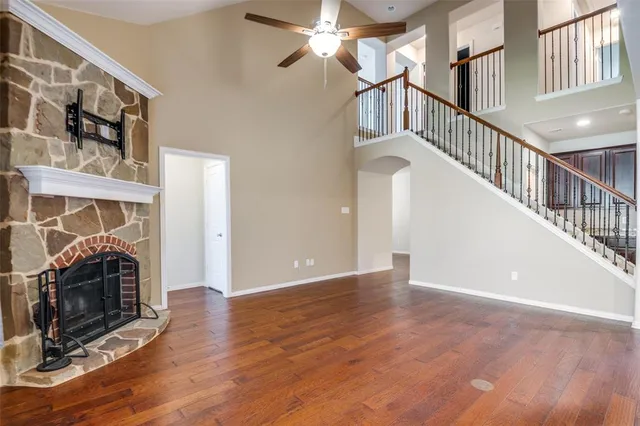 a view of a livingroom with wooden floor fireplace and a window