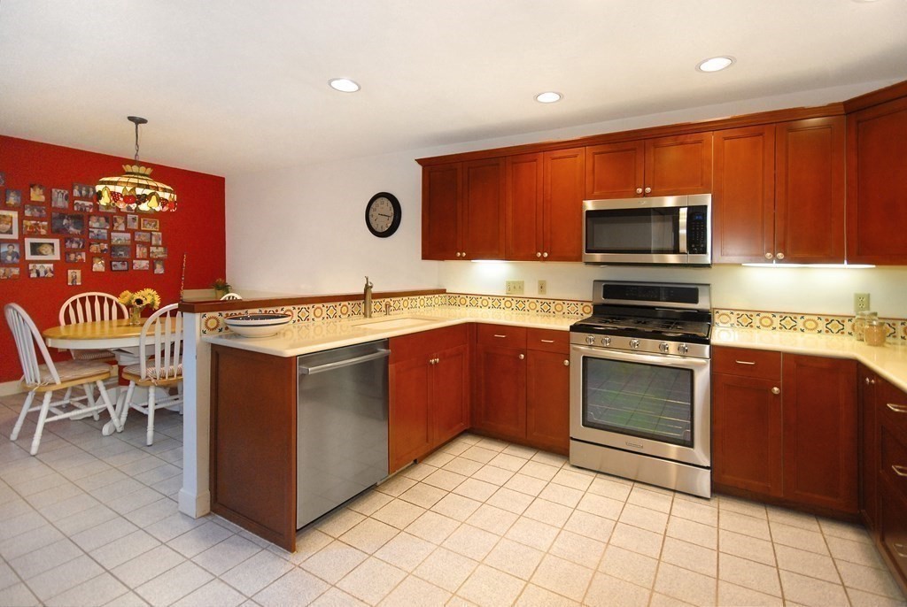 6 Winterberry Path, Unit 6 Acton, MA 01720 - Photo 4 of 24 a kitchen with stainless steel appliances granite countertop a stove microwave and sink