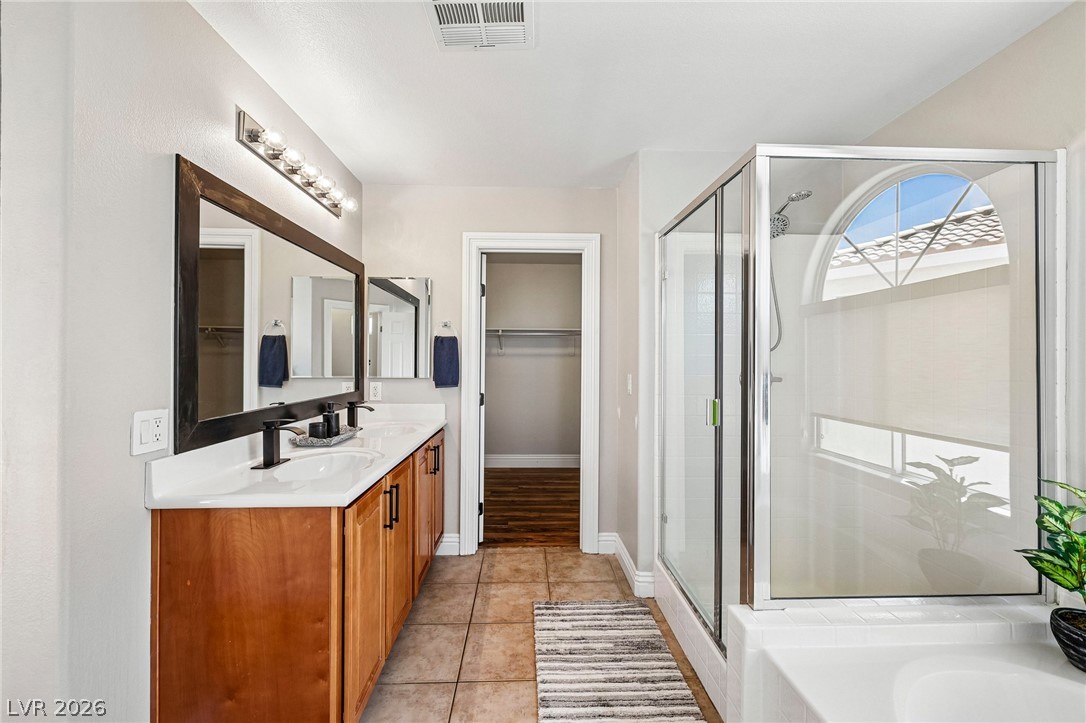 1176 Butternut Ranch Court Henderson, NV 89052 - Photo 38 of 60 Double vanity and a spacious glass-enclosed shower create a practical and well-appointed bathroom.
